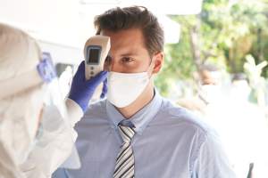 Man with a mask having his temperature checked